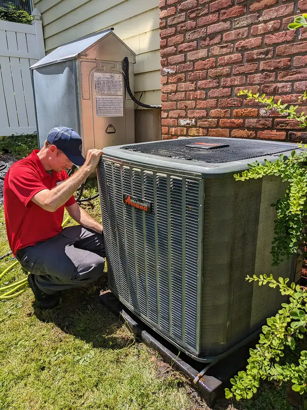 Mark lindsay service technician working on ac unit outside residential home.