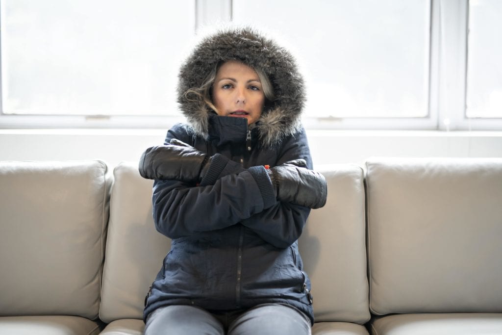 woman cold at home because furnace isn't working