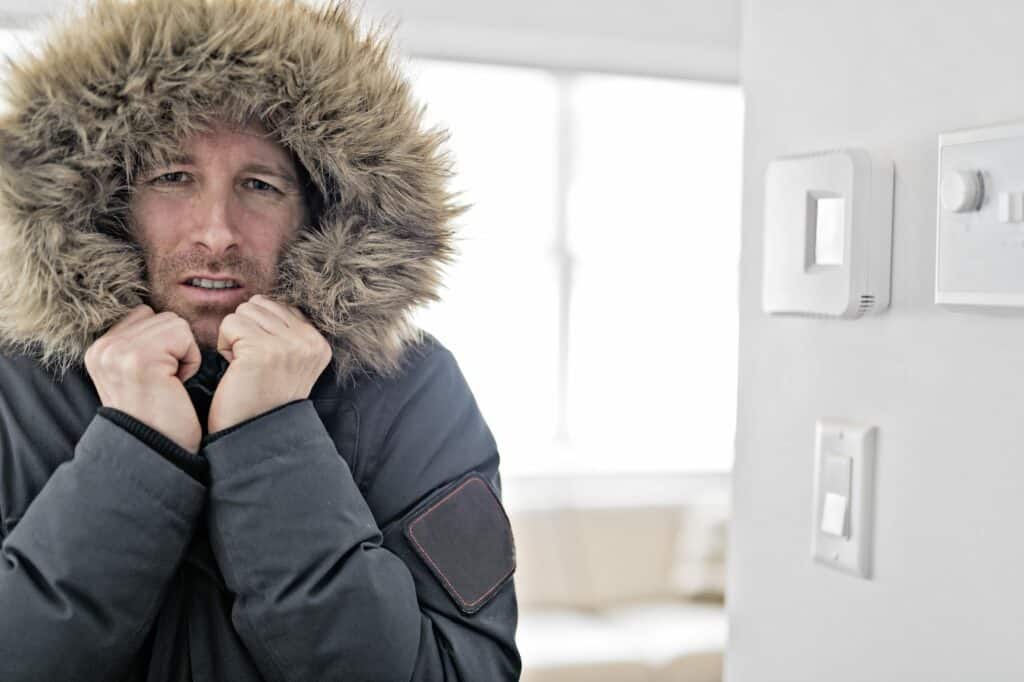 man freezing at home due to broken heating system