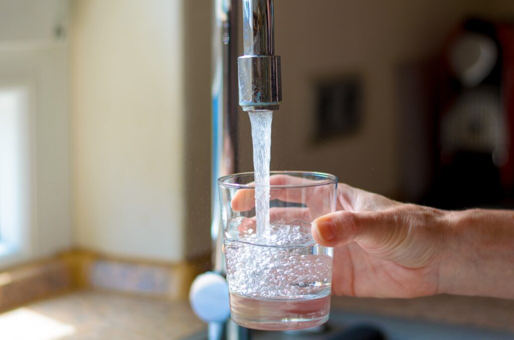 filling up a glass of water from a tap