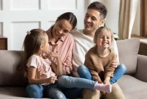 family sitting on couch, laughing together