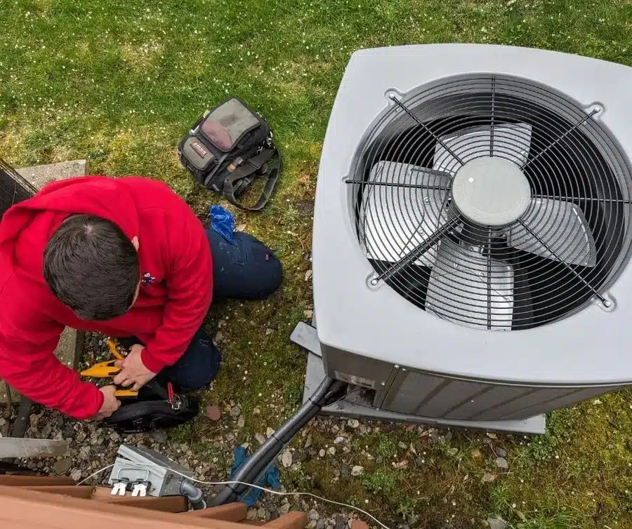 Mark Lindsay technician servicing outdoor AC condenser in West Milford area, performing professional air conditioning repair and maintenance work