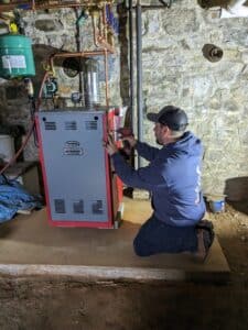 Mark Lindsay employee fixing boiler downstairs in basement