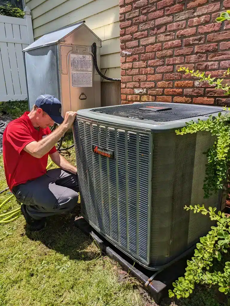 Mark lindsay service technician working on ac unit outside residential home.