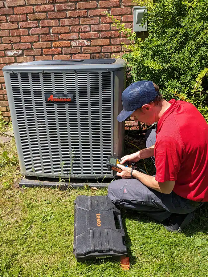 Mark Lindsay technician testing ac unit outside of residential home.