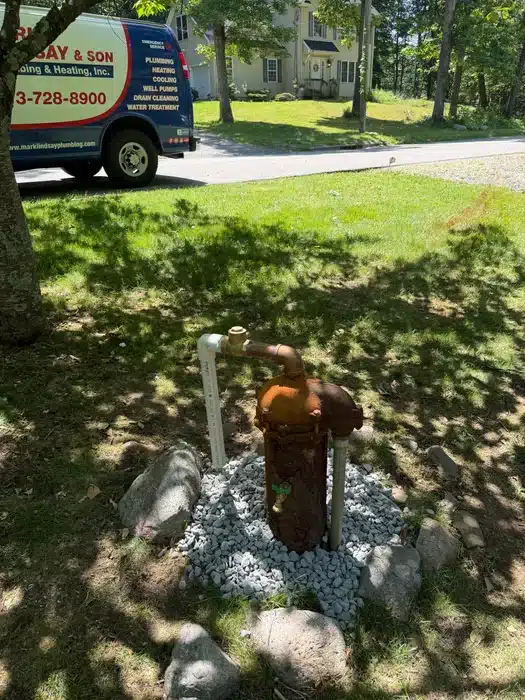 Corroded residential well casing ready for replacement with Mark Lindsay & Son Plumbing service van in the background