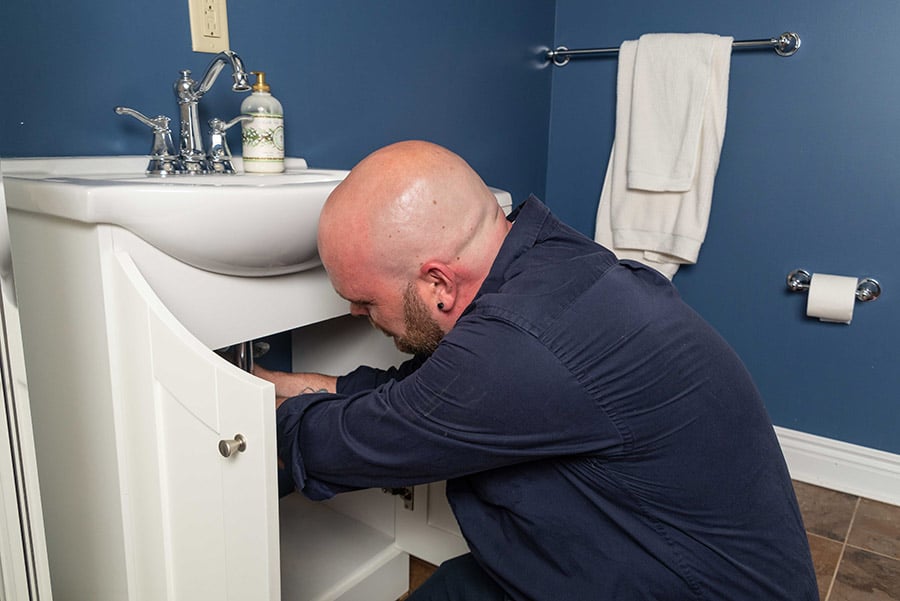 https://www.marklindsayplumbing.com/wp-content/uploads/plumber_fixing_under_sink2.jpg