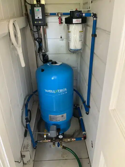 WellXtrol pressure tank and whole-house sediment filter installed by Mark Lindsay Plumbing in a residential well pump room